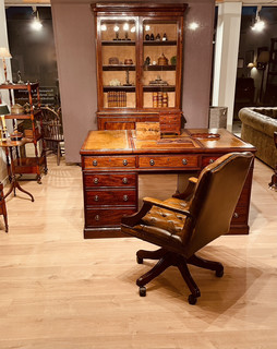 A 19th Century Mahogany Partner's Desk having Two Reading Slopes. A 20th Century Chesterfield Desk Chair. A Victorian Mahogany Bookcase.