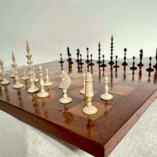 A 19th Century Selenus Bone Black and White Chess Set on a 19th Century Oak Chess Board with Rosewood and Satinwood Marquetry.