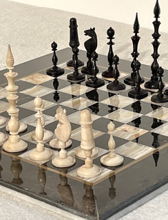 A 19th Century Selenus Bone Chess Set on a 19th Century Pietra Dure Marble Chess Board.