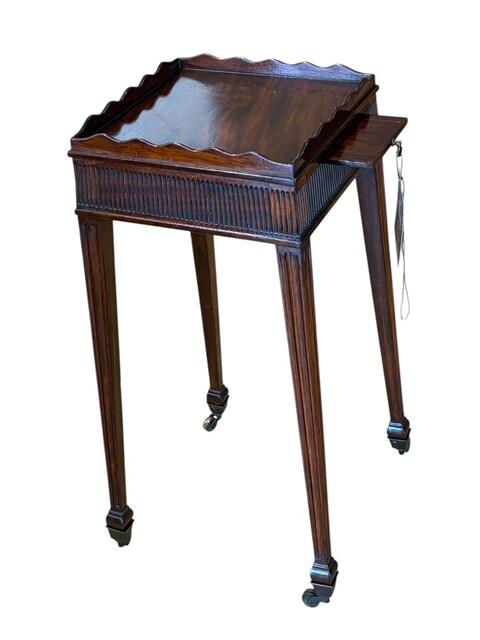 A fine George III mahogany kettle stand, circa 1810, with a shaped gallery, reeded frieze, pull out slide and brass castors.