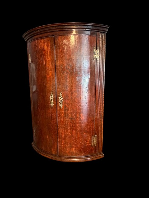 A fine Welsh oak hanging corner cupboard from the 18th century, with beautifully figured oak, elegant proportions, a shaped cornice and a rich original patina.