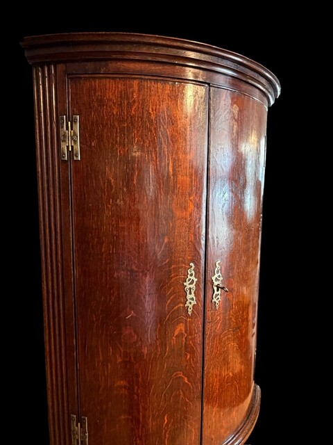 A fine Welsh oak hanging corner cupboard from the 18th century, with beautifully figured oak, elegant proportions, a shaped cornice and a rich original patina.