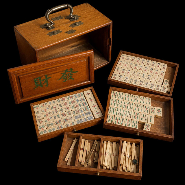 An early 20th century Chinese Mahjong set housed in its original hardwood carrying case, complete with hand engraved bone and bamboo tiles, five removable drawers and original scoring sticks.
