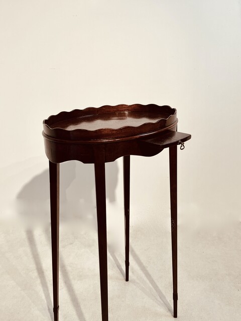 An English 19th Century Mahogany Kettle Stand having an Oval Top with Scalloped Gallery.