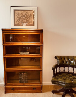 An English 19th Century Oak Globe Wernicke Bookcase. Four Sections High. A Green leather Captains Desk Chair