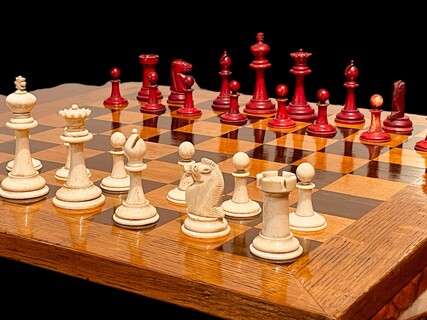An English 19th Century Staunton Chess Set and an English 19th Century Oak / Rosewood / Satinwood Chess Board.