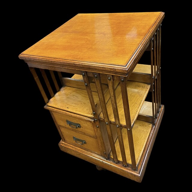 An English Arts and Crafts Oak Revolving Bookcase having two drawers. Metal Base.