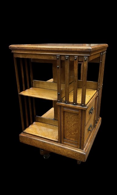 An English Arts and Crafts Oak Revolving Bookcase having two drawers. Metal Base.