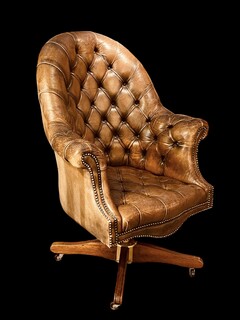 An English Early 20th Century Revolving Chesterfield Desk Chair having a reclining mechanism and is adjustable in hight.