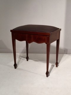 An English Edwardian Mahogany Piano Stool with Satinwood Inlay and having music sheet storage.