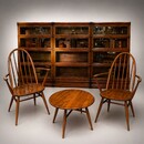 An English Ensemble of a pair of 1950s Ercol Chairs and Coffee Table in front of Three 19th Century Globe Wernicke Bookcases.